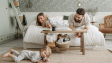 A joyful family bonding in a cozy bedroom, featuring a playful child and loving parents.